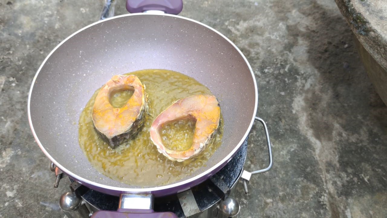 Placing fish pieces to the hot oil to fry
