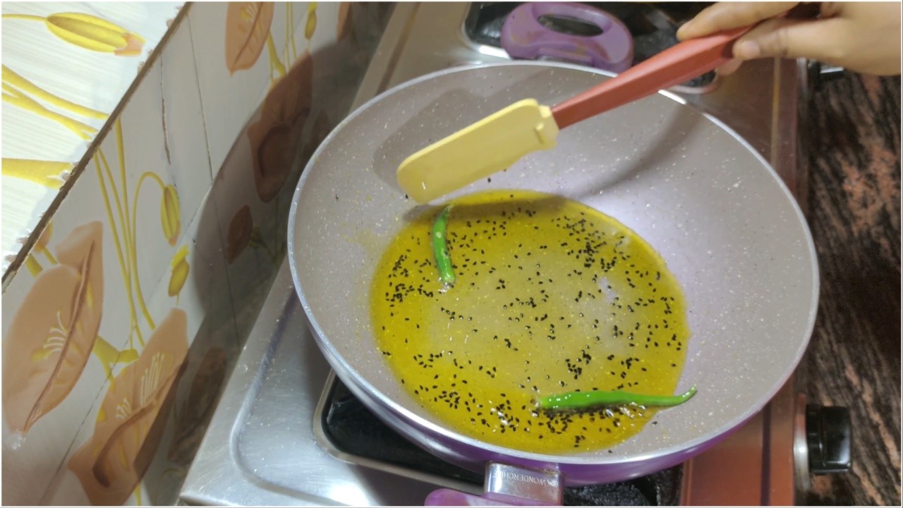 Adding two green chilies and stirring