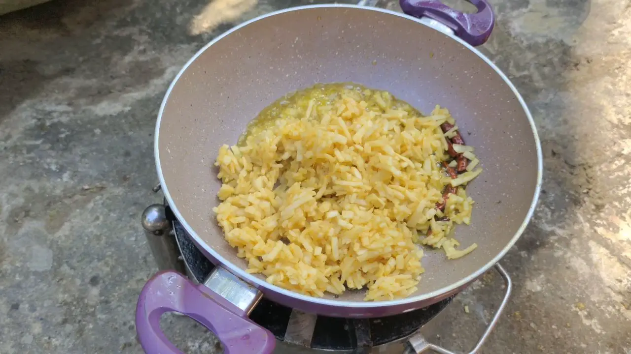 Adding banana stems to the cooking pan