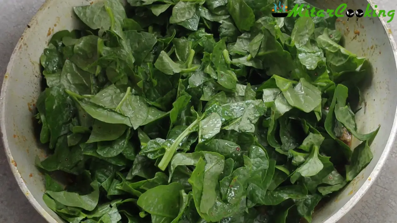 Spreading the Malabar spinach over the curry