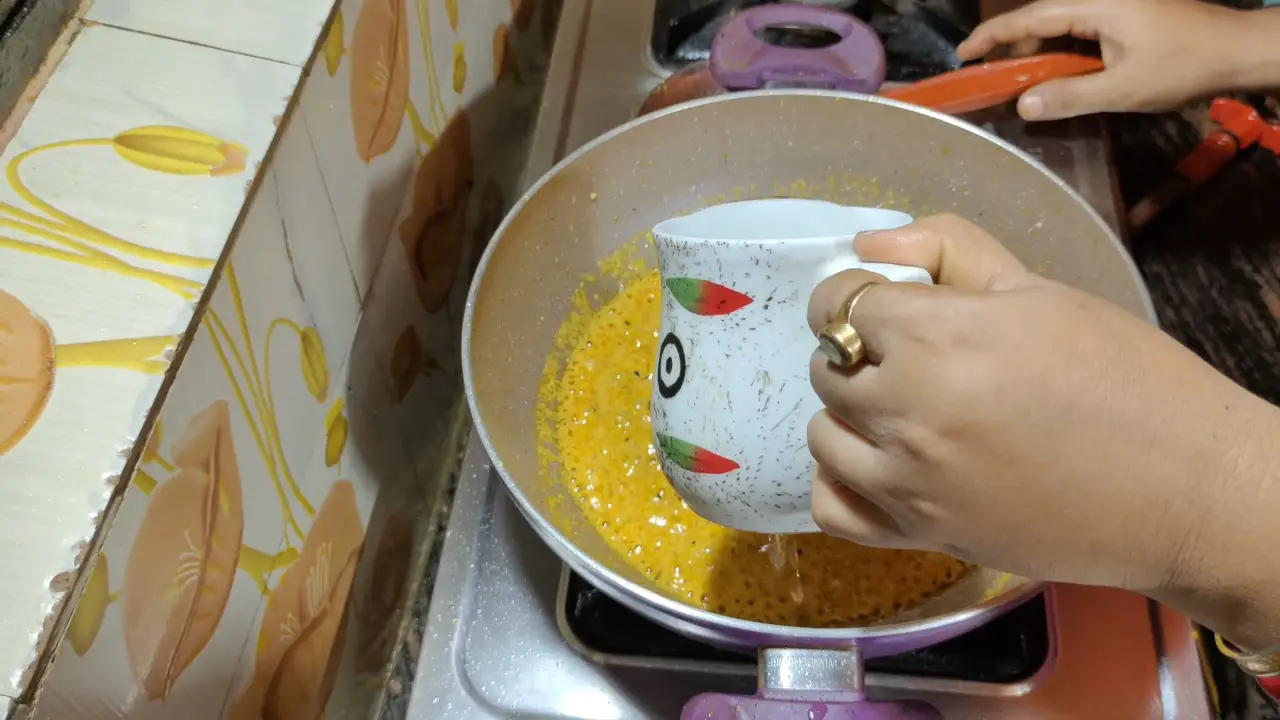 Pouring 1 cup of water into the pan