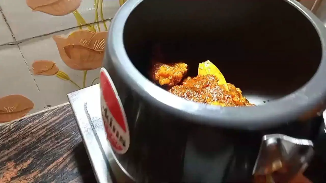 Transfer mutton curry to a pressure cooker