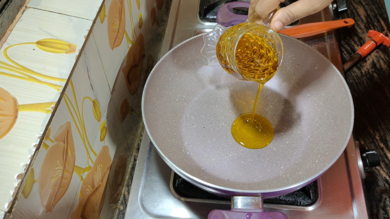 Pouring mustard oil into the pan