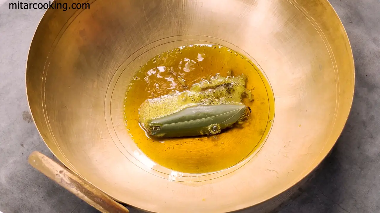 Adding whole spices such as bay leaves, cinnamon sticks, green cardamoms, black cardamom, cloves, and cumin seeds