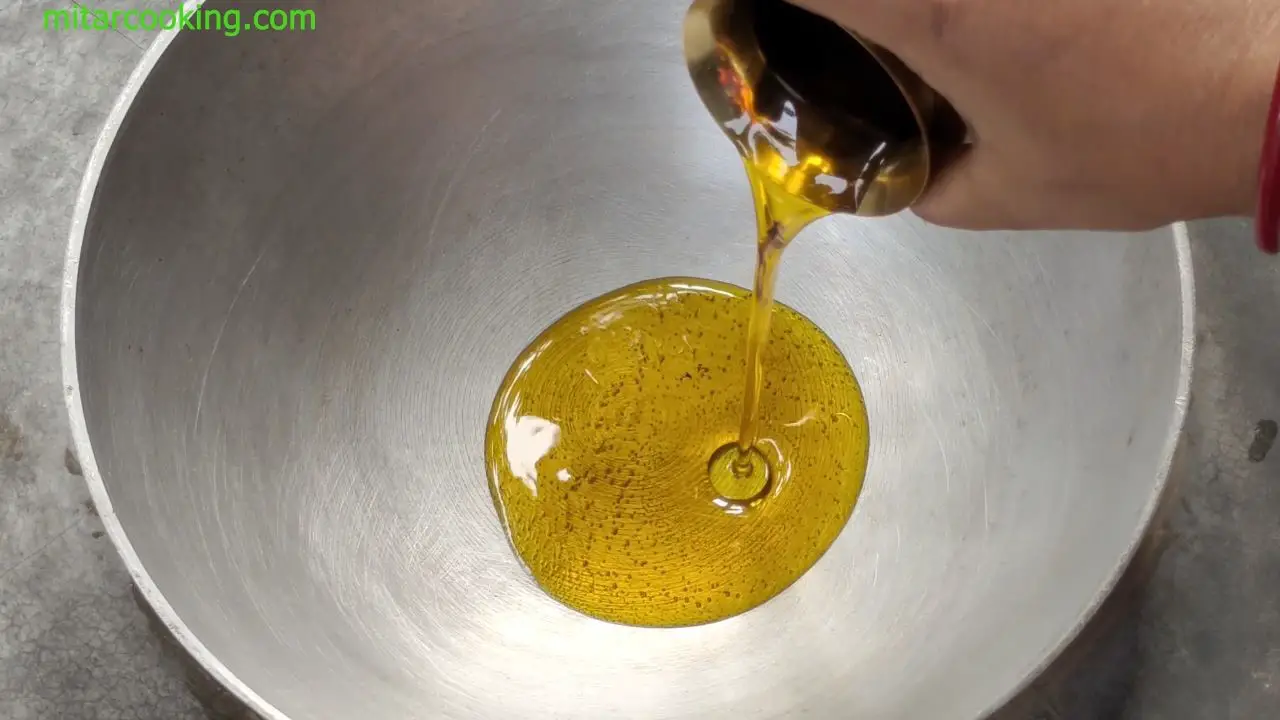 adding oil in the kadai