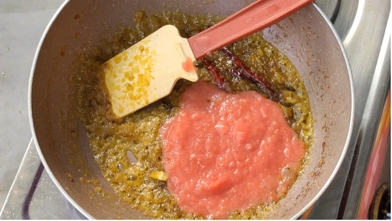 Adding tomato paste in the cooking pan