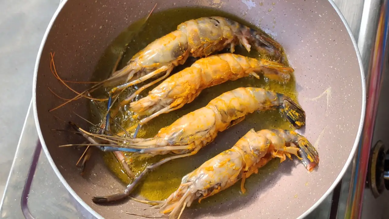 Add prawns in the heated mustard oil