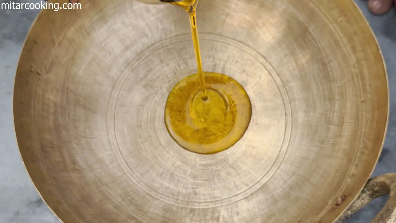 Adding mustard oil to the heated pan.