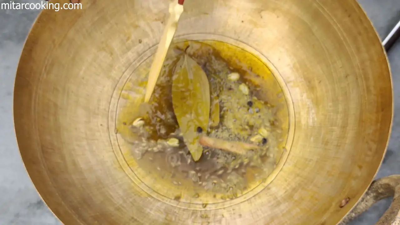 Adding the whole spices such as bay leaves, cinnamon sticks, green cardamoms, cloves, pepper and cumin seeds to the oil and Sautéing