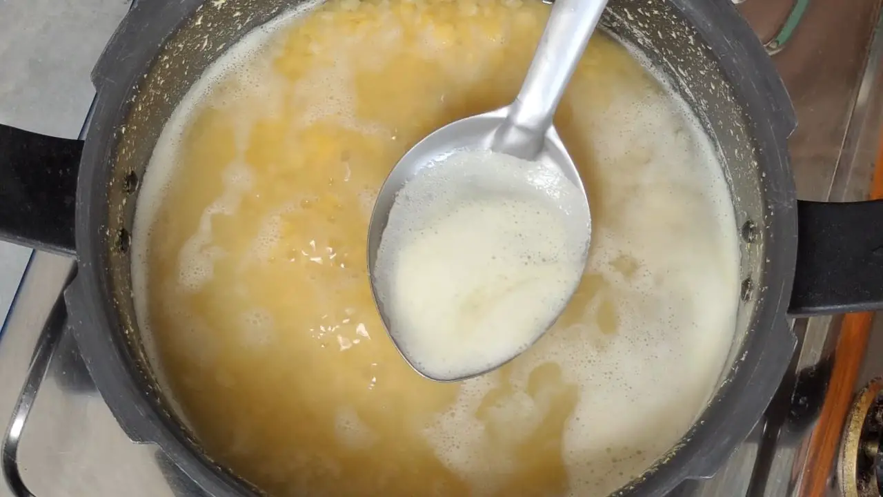 ladle out the white foam from dal.
