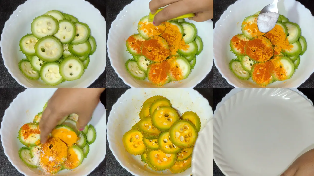 Coating kakrol or spiny gourd with red chili powder, turmeric powde, salt and mixing