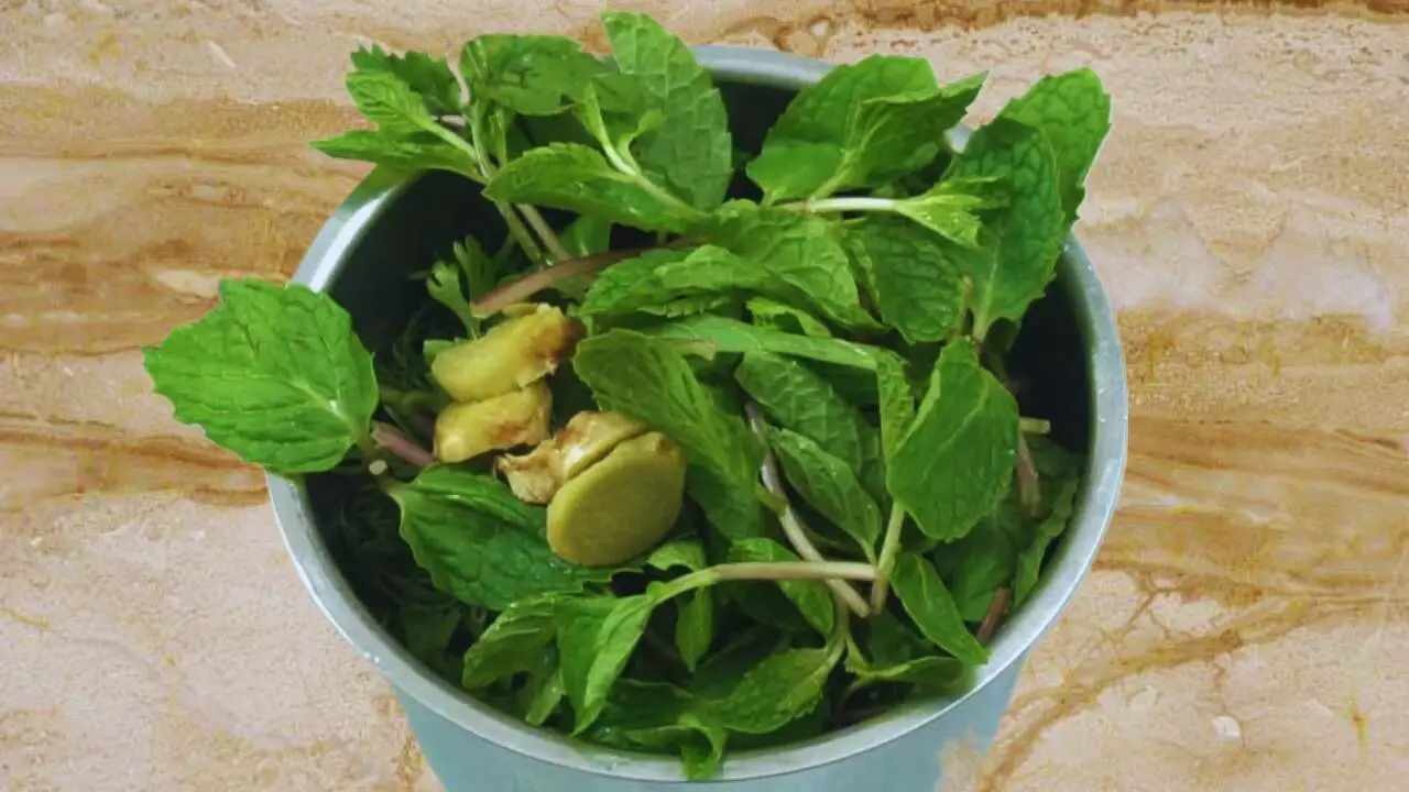 Adding 2 pieces of 1-inch size fresh and deskinned ginger, cut into small pieces, in the grinder