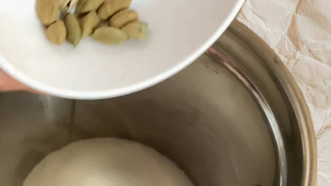 Adding 10 fried green cardamom pods to the sugar in the grinder