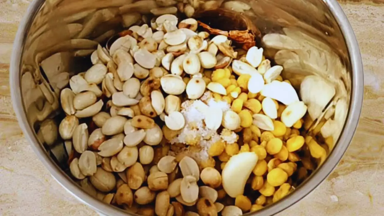 Adding 3 tbsp of roasted peanuts into the grinder