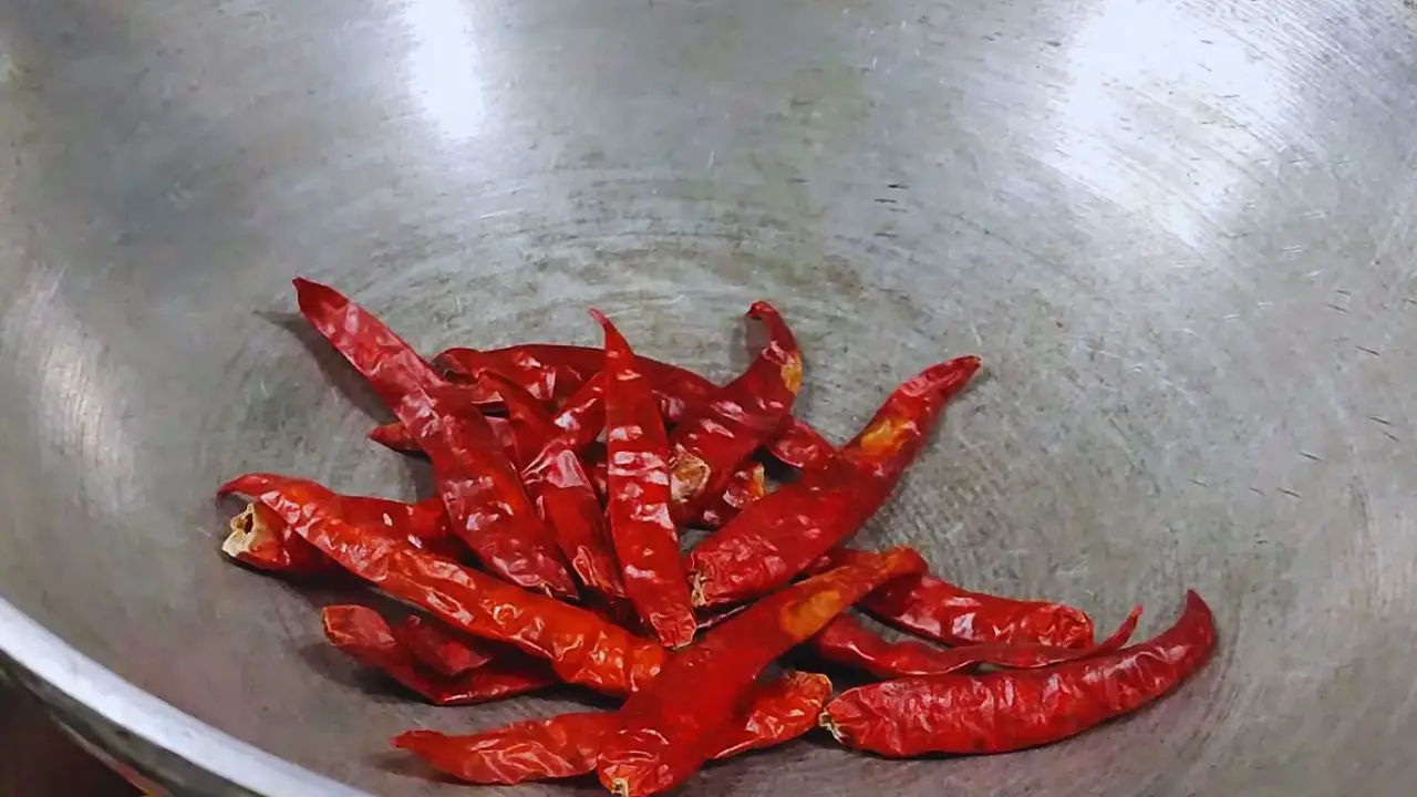 Putting 15 pieces of dry red chilies of medium size in the wok