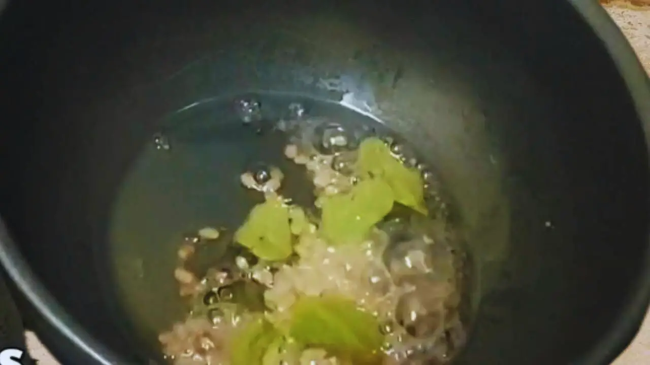 Pouring 1 tbsp white oil. Then add ½ tsp mustard seeds, 1 tsp black gram split (urad dal), and 6 pieces of curry leaves to the pan