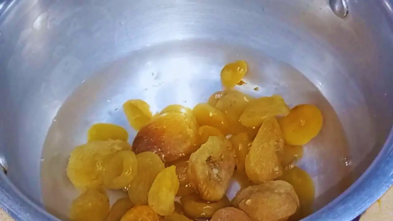 Pouring 3 cups of water into it and put 100 gms of dry and deseeded apricots in wok