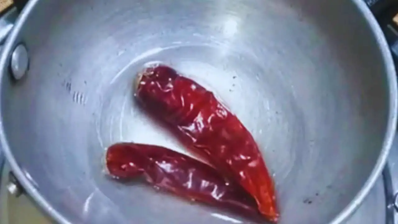 Putting 2 pieces of dry red chilies in it