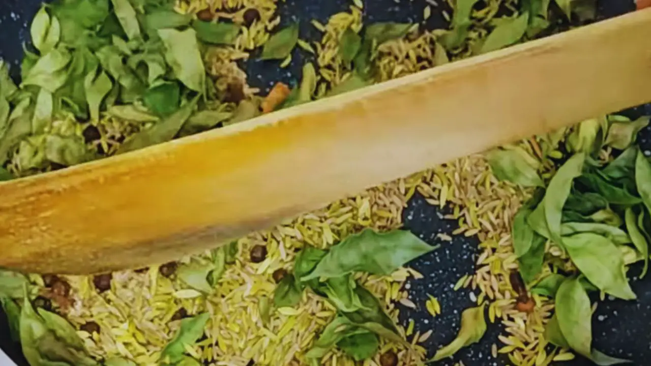 Stirring the content until the curry leaves are dry