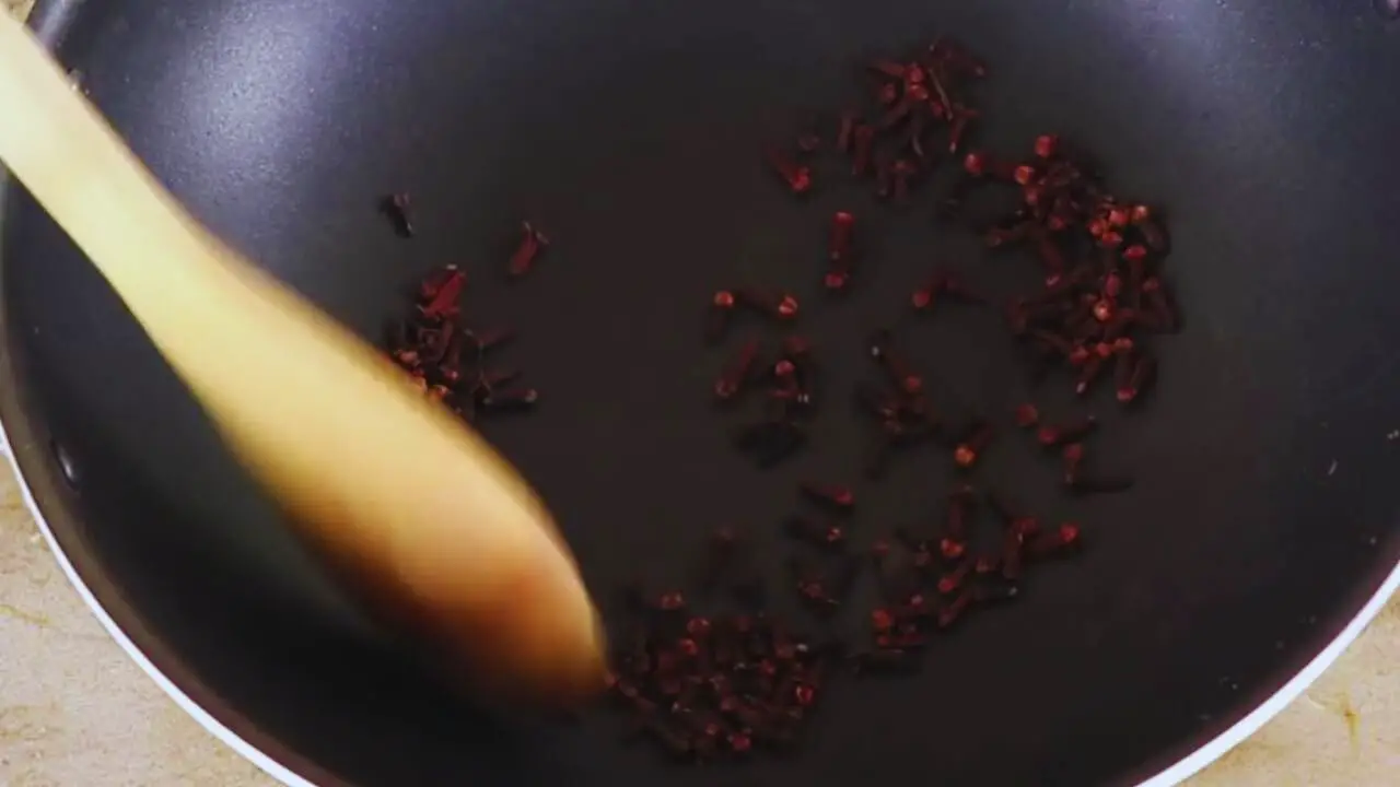 Stirring them until you can smell the aroma of roasted cloves