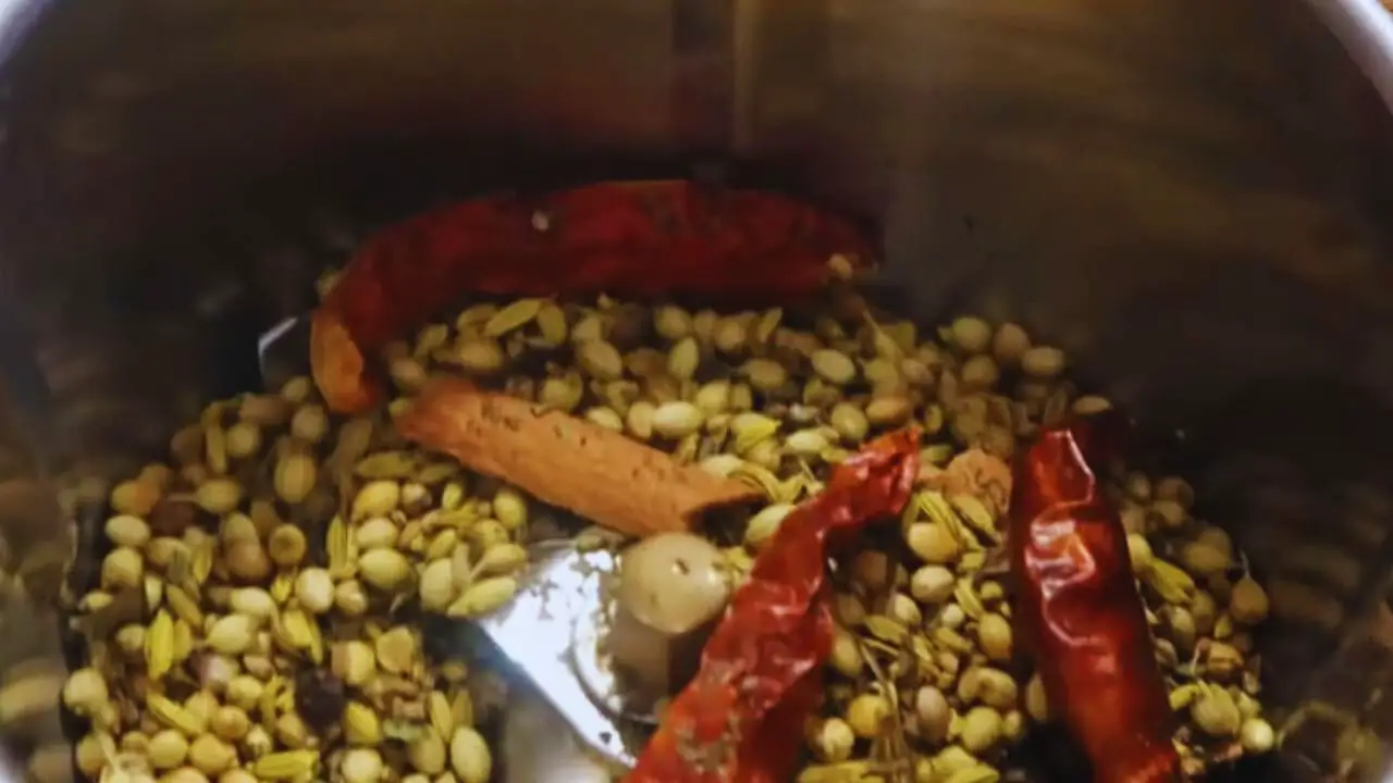 Putting all the roasted spices into the grinder