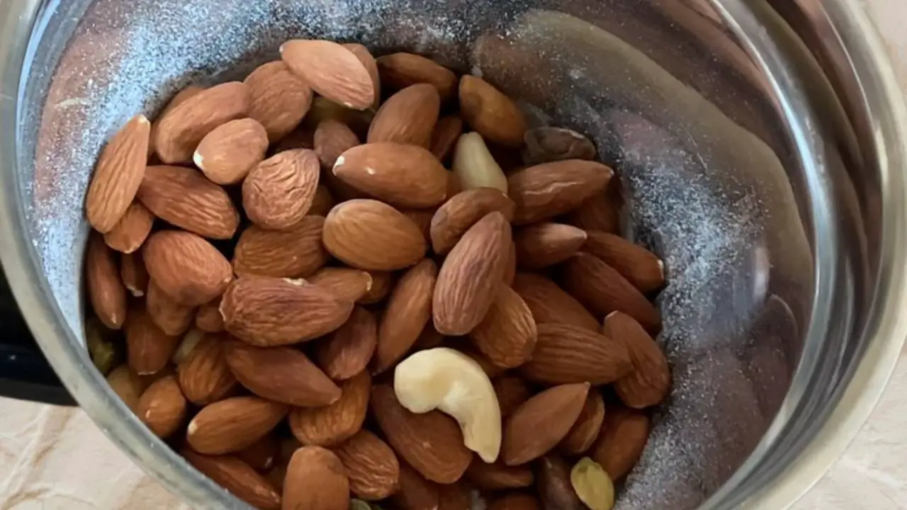 Transferring the cooled nuts into the grinder