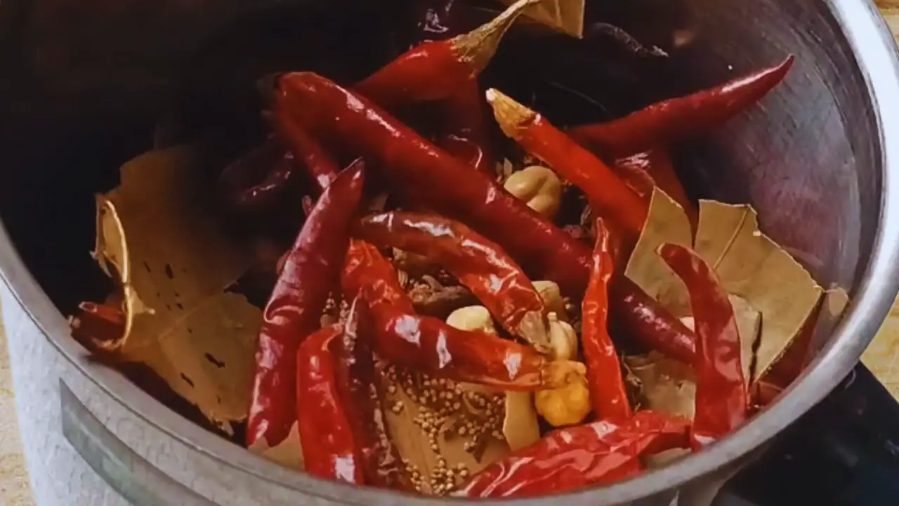 Transferring the roasted ingredients into the grinder