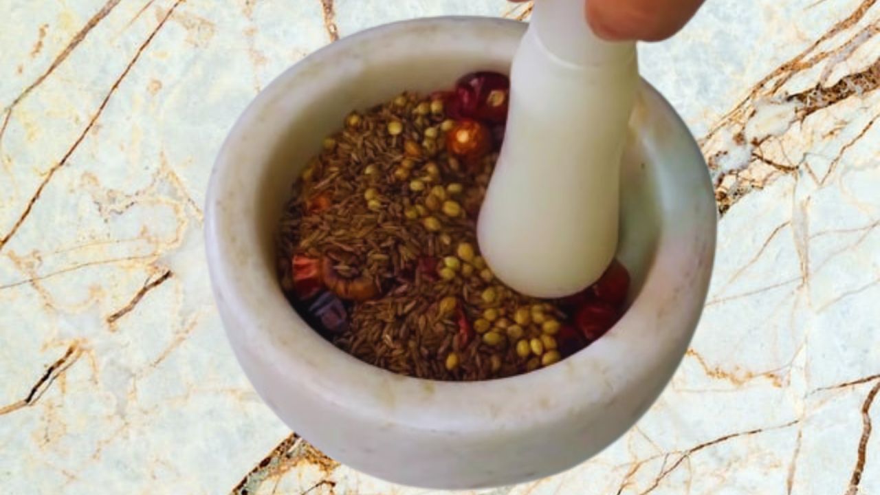 Transferring the roasted spices into a mortar & pestle