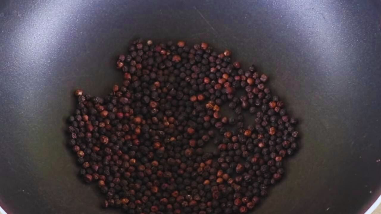 Putting 40 gms of black pepper (kali mirch) into the wok