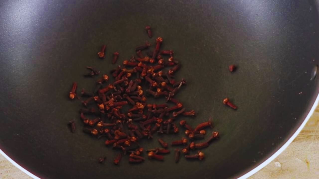 Putting 10 gms of cloves (laung) in the wok