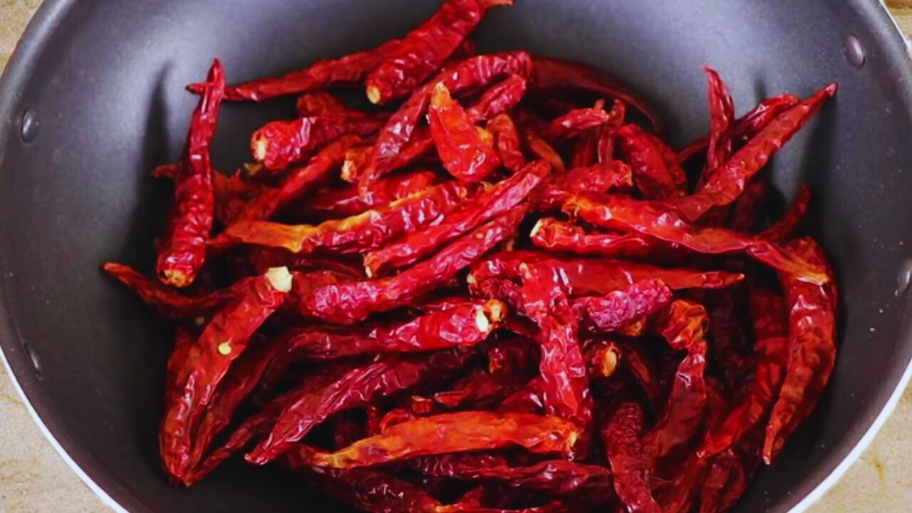 Putting 100 gms of dry red chilies (laal mirch) into the wok