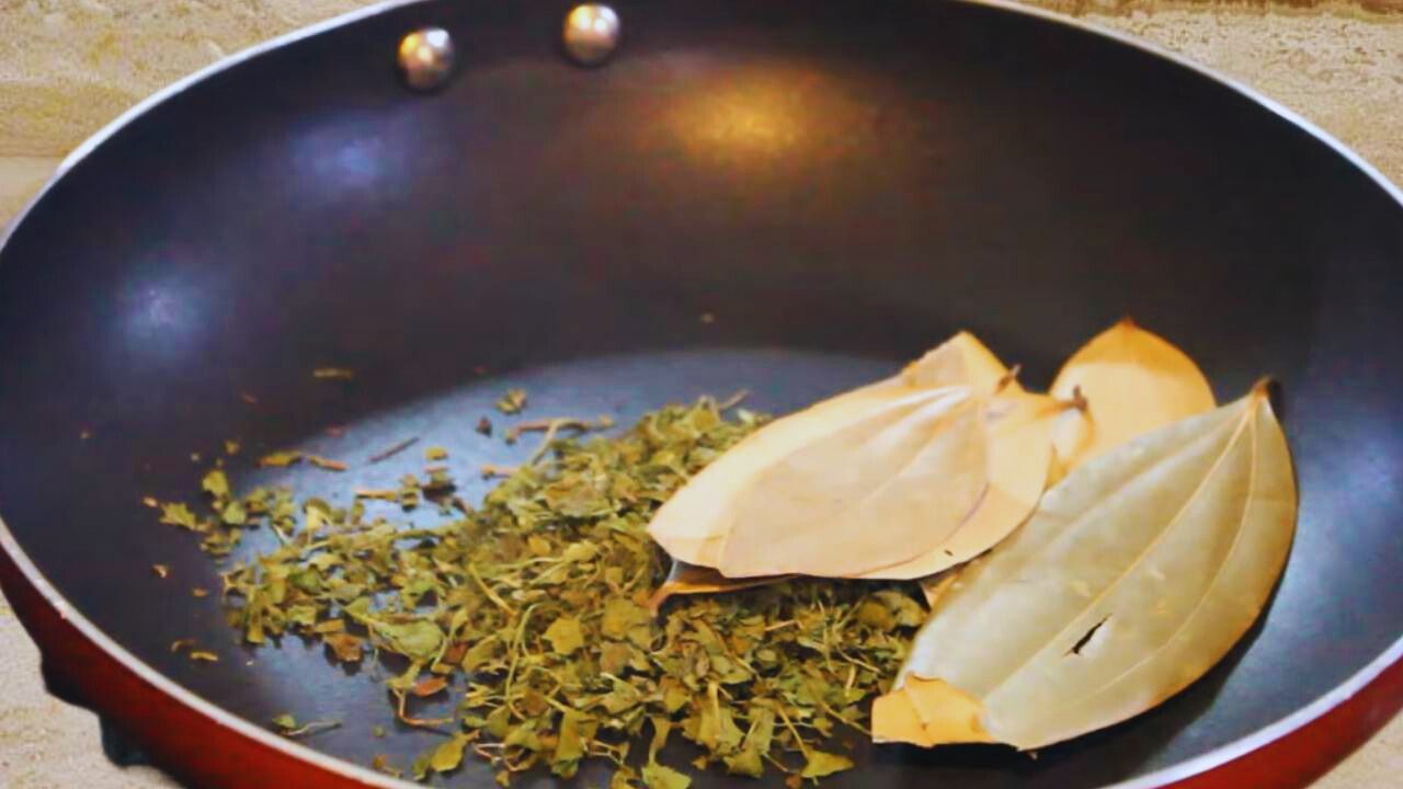 Adding 2 tsp of dry fenugreek leaves (kasturi methi) and 5 medium pieces of bay leaves in frying pan