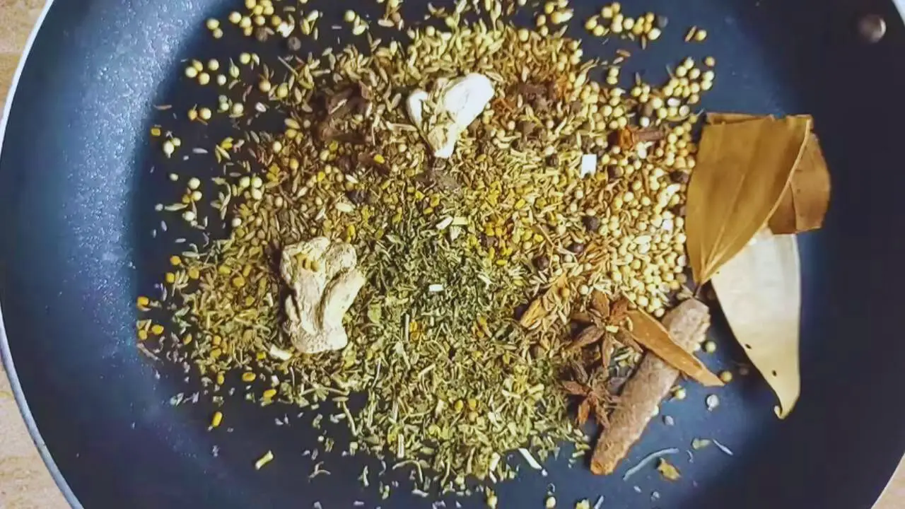 Putting 2 tbsp coriander seeds, 1 tbsp cumin seeds, 1 tbsp black cumin seeds (Bunium persicum), 1/2 tbsp fennel seeds, ½ tbsp fenugreek seeds, ½ tbsp black pepper, 1 tbsp dry fenugreek leaves (kasturi methi), 2 pieces of star anise, 2 medium pieces of dry ginger, 8 pieces of cloves, 2 pods of black cardamom, 3 medium-sized cinnamon sticks, and 2 bay leaves in frying pan