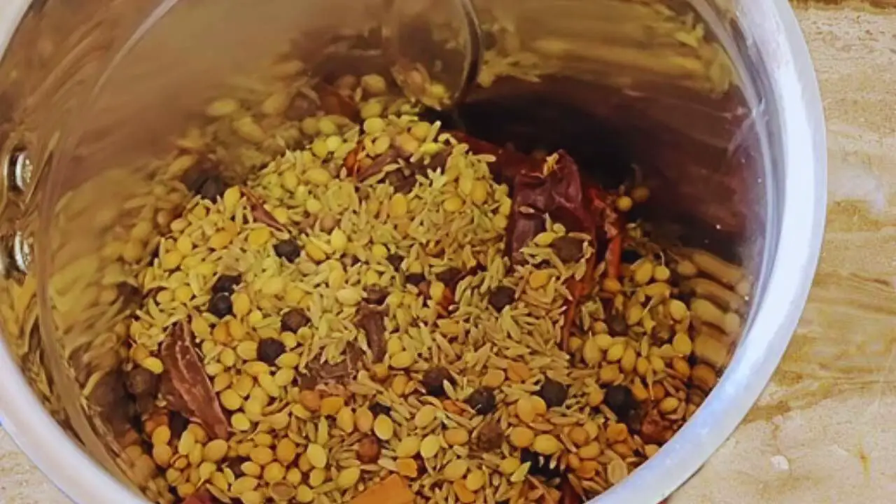 Transferring the roasted spices to the grinder