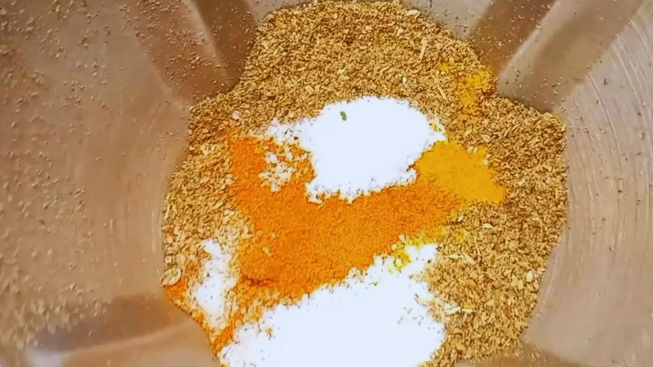 Adding 2 tbsp of Kashmiri red chili powder, 1 tbsp of red chili powder, 1 tsp of turmeric powder, and 1 tbsp of salt and grind them all together once again