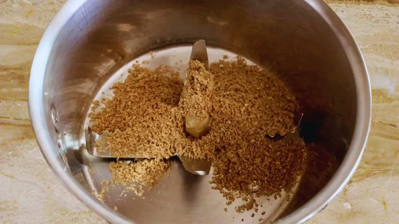 Putting 2 tsp of coriander powder in the grinder
