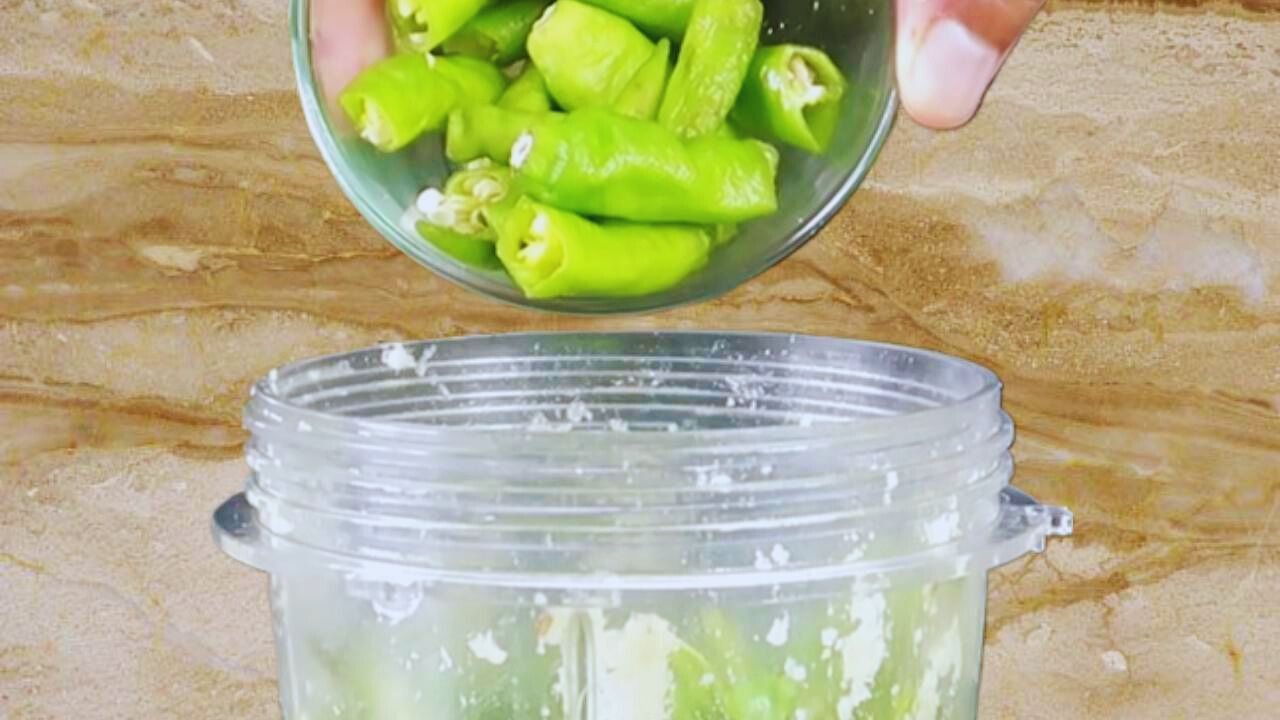 Adding 4 pieces of fresh green chilies to the grinder