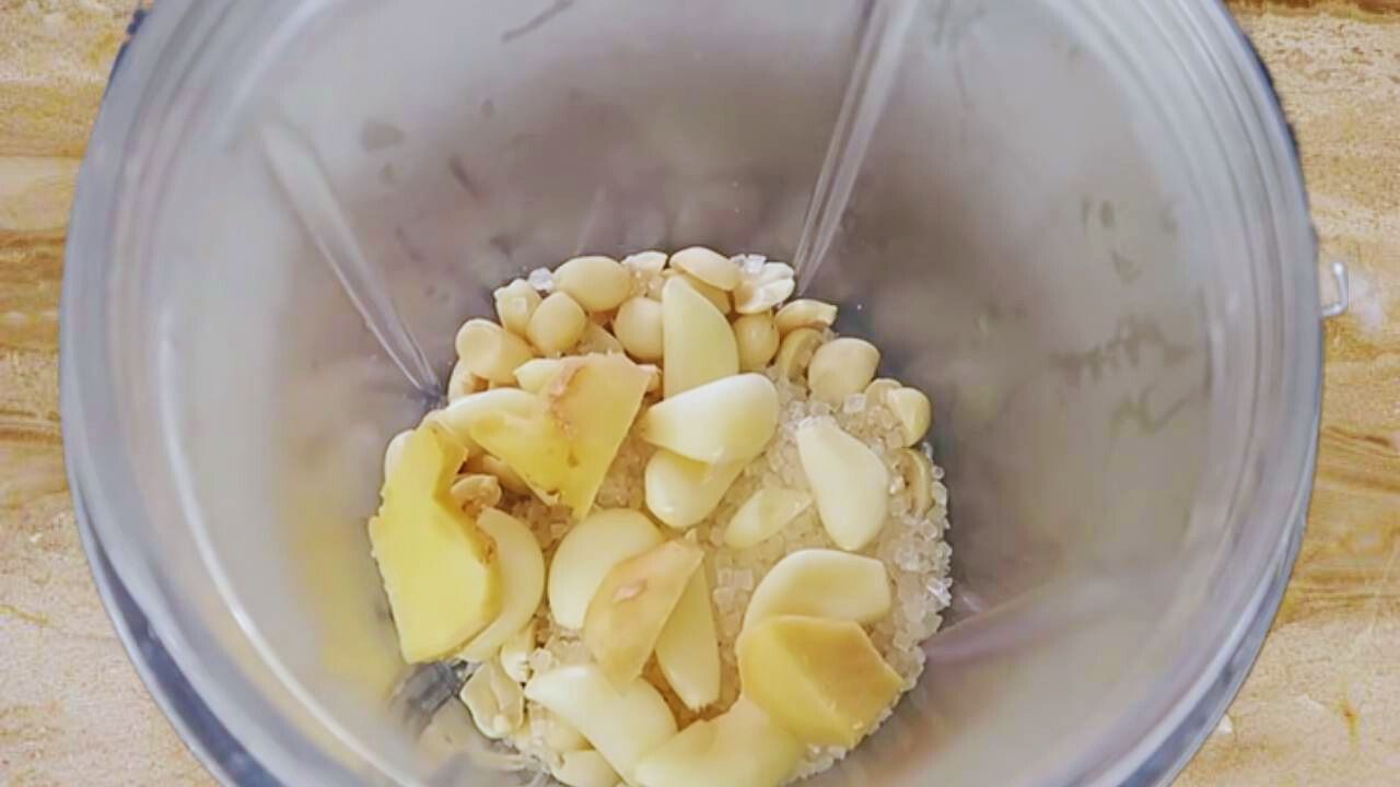 Adding a piece of fresh ginger of 2-inch size, diced into small pieces, into the grinder