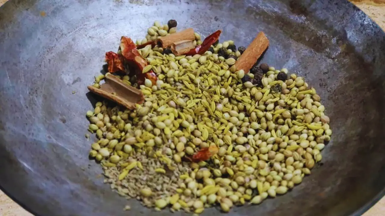 Put 4 pieces of dry red chilies, 4 cinnamon sticks of 1-inch size, ½ tsp of black pepper, 1 tsp of fennel seeds, 3 tsp of coriander seeds, ½ tsp of carom seeds (ajwain), and 1.5 tsp of dry spearmint (pudina) powder wok