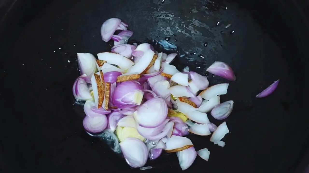 Adding 1 small slice of chopped coconut and 5 small pieces of onions, chopped roughly