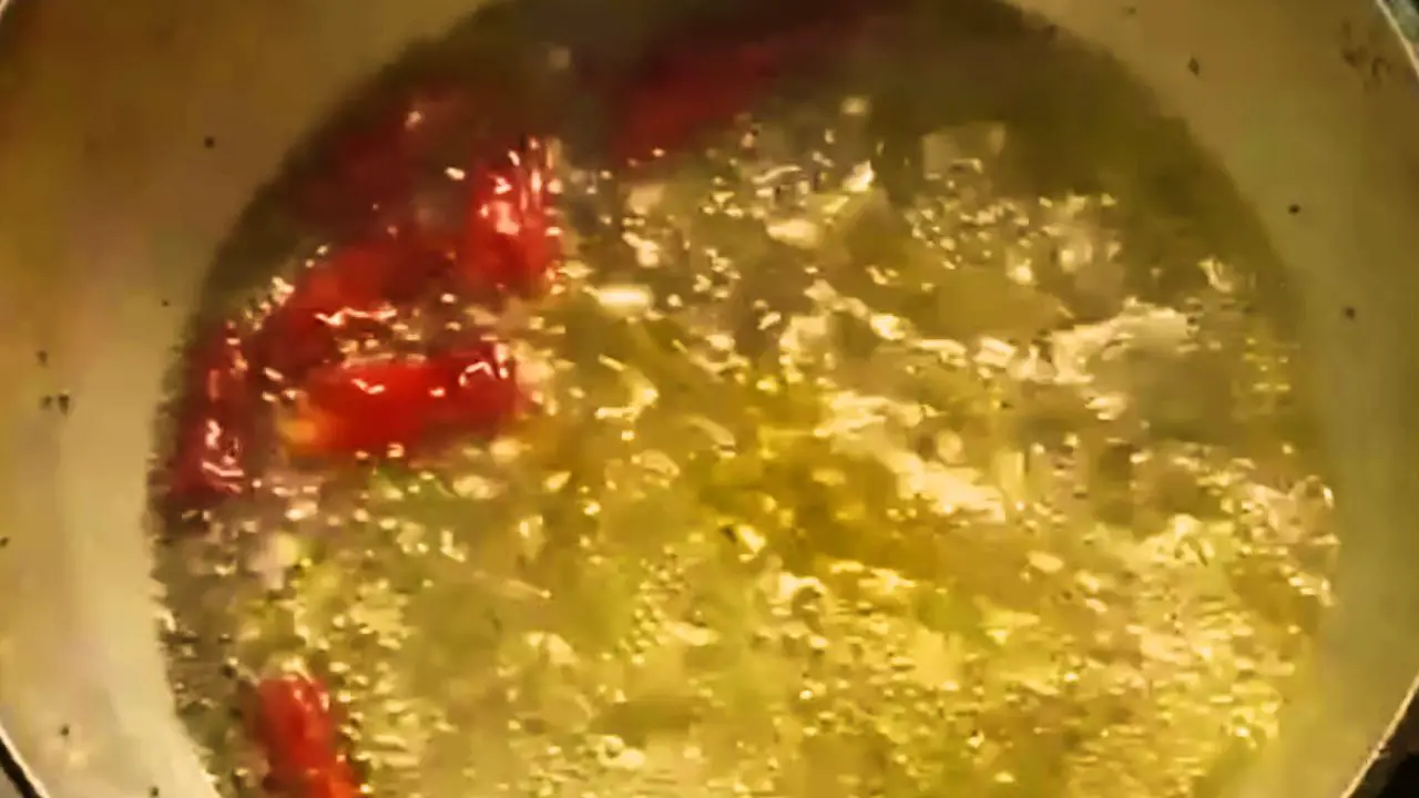Added 3 cups of refined oil, and heat it. Then add 2 tbsp of mustard seeds and 1 tbsp of asafoetida. Turn off the flame and add 5 dry red chilis into the oil