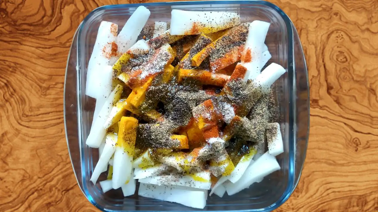 Added 1 tbsp turmeric powder, 1 ½ tbsp carom seeds, 1 tbsp red chili powder, 2 tbsp salt, ground mustard seeds, 1/4th cup mustard oil, and 2 tbsp vinegar into the mixing bowl