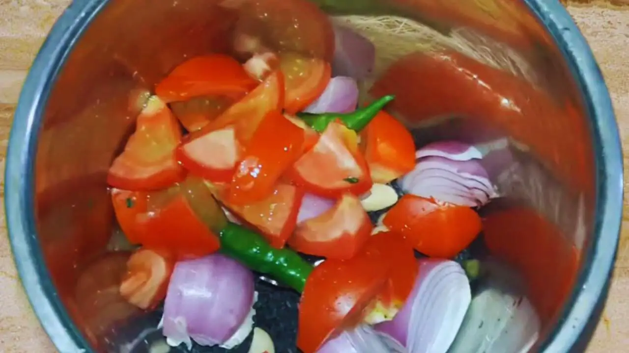 Adding tomato pieces to the ingredients for a tangy black sesame chutney