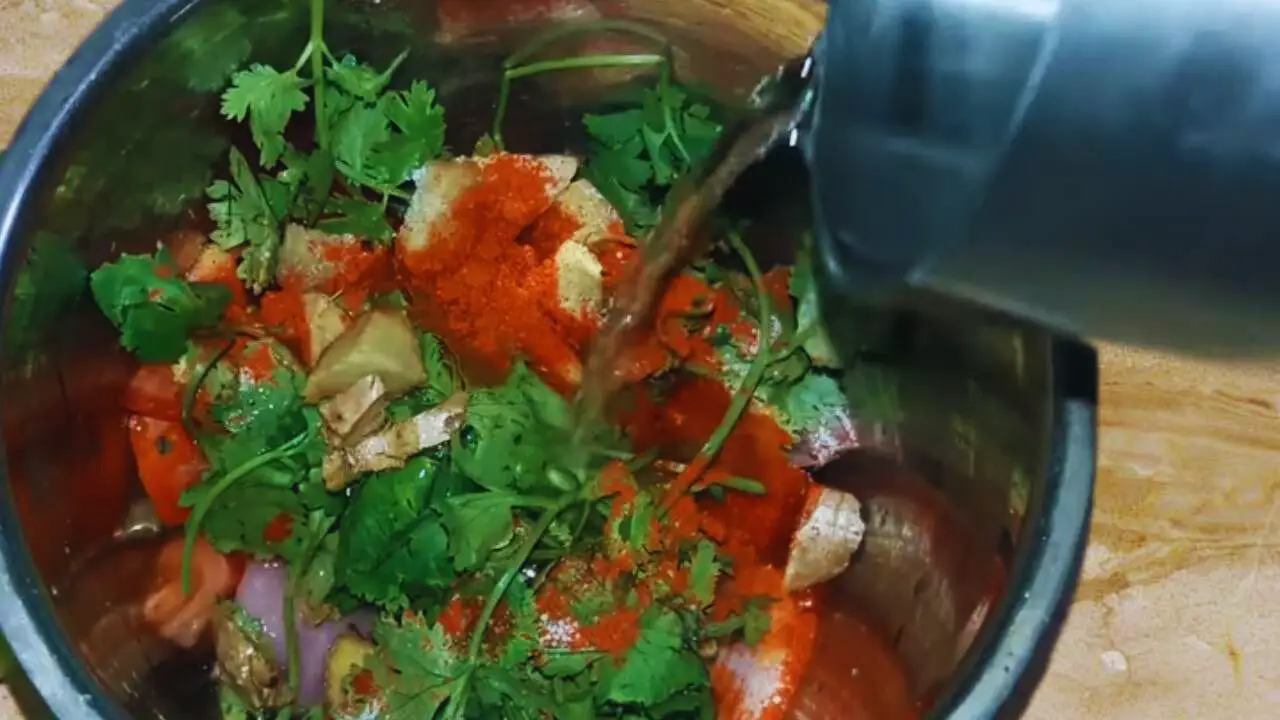 Adding water to grind the ingredients for black sesame chutney