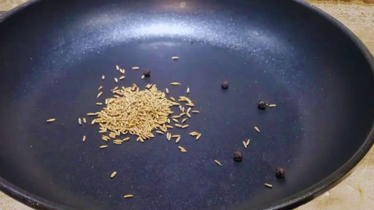 Putting 1 tsp of cumin seeds and 4 to 5 pieces of black pepper in frying pan