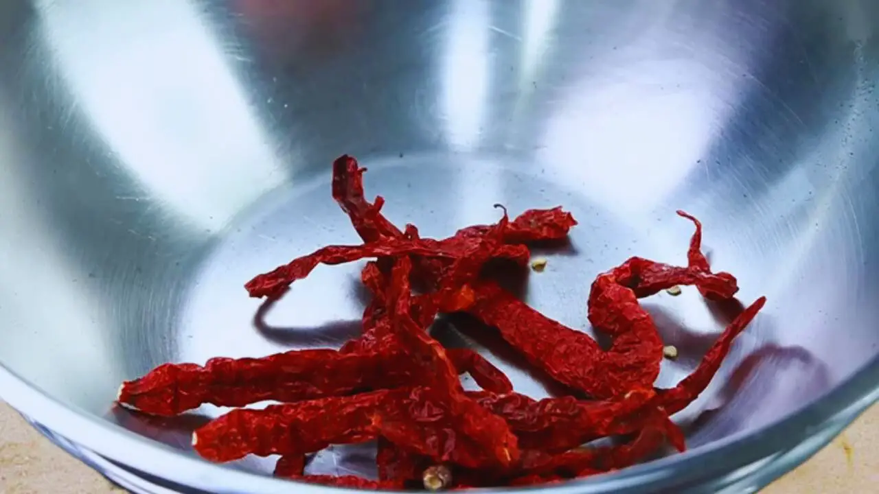 Adding 10 to 12 pieces of dry red chilies