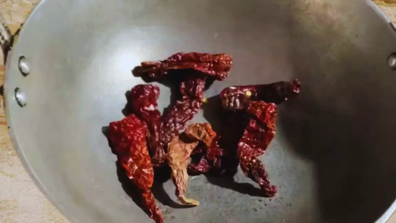 Putting 8 to 10 pieces of Kashmiri red chilies in wok