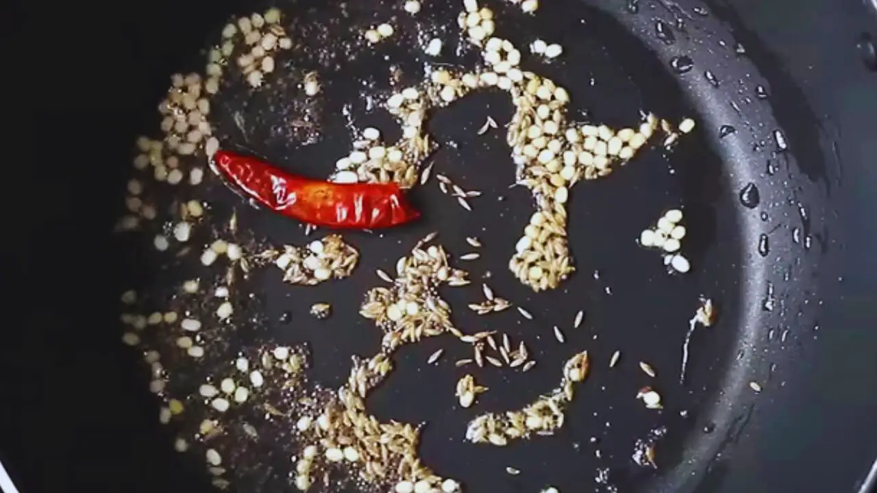 Putting one piece of dry red chili without its stalk
