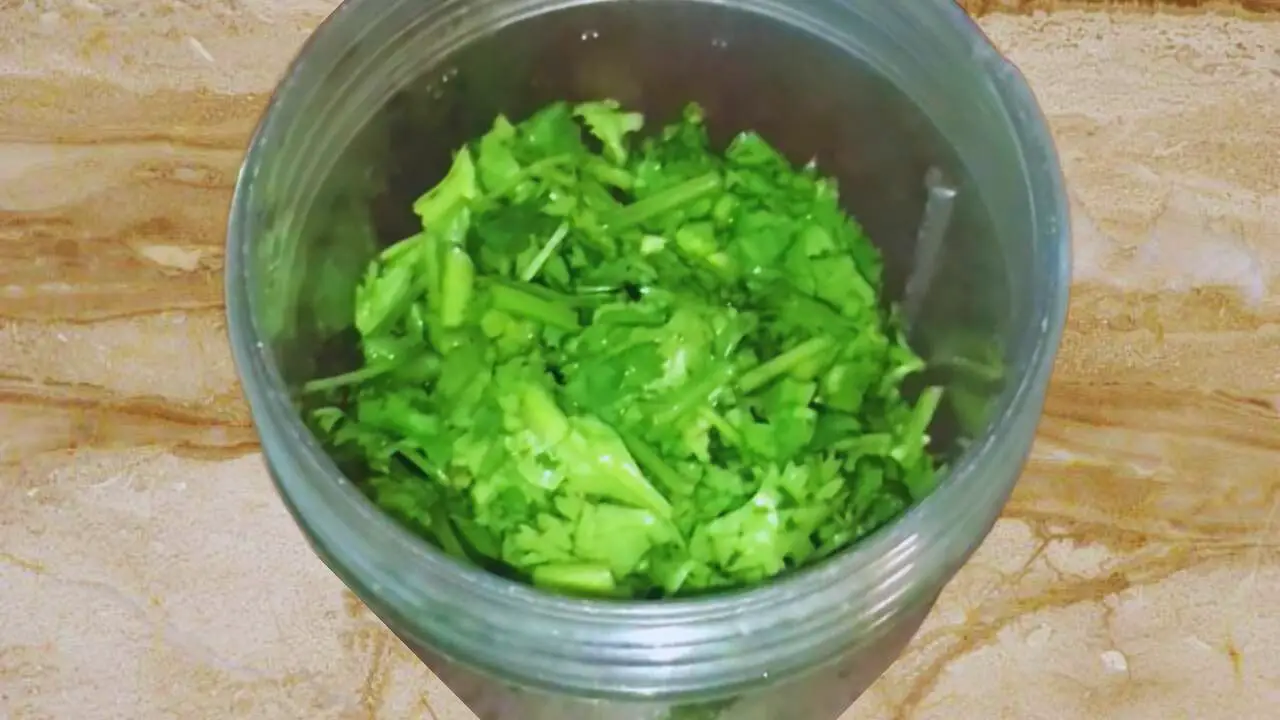Putting 1 cup of fresh coriander leaves in grinder