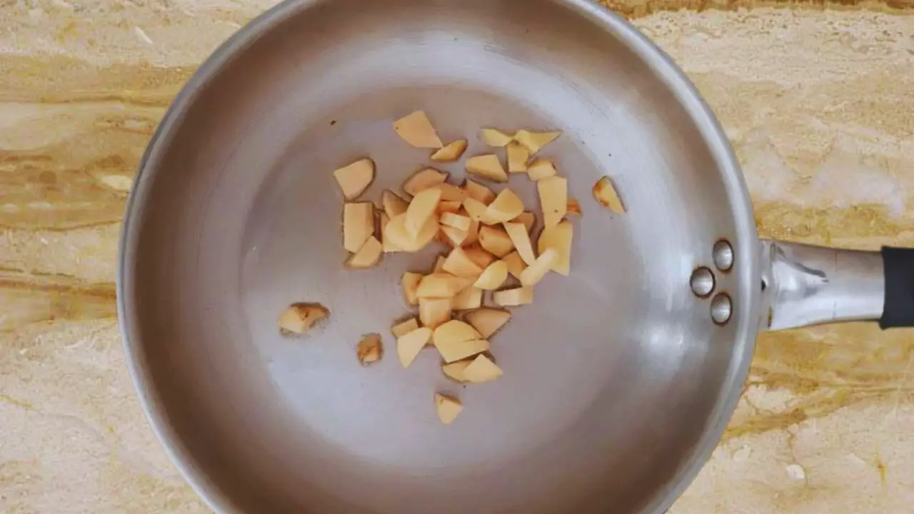 Putting 2 tbsp of white oil, ¼ cup of fresh ginger, deskinned and chopped roughly, into the pan